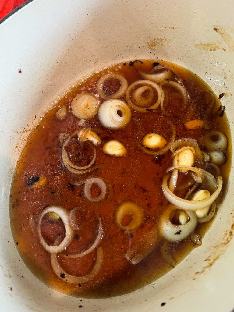 sliced onions and beef broth in a dutch oven