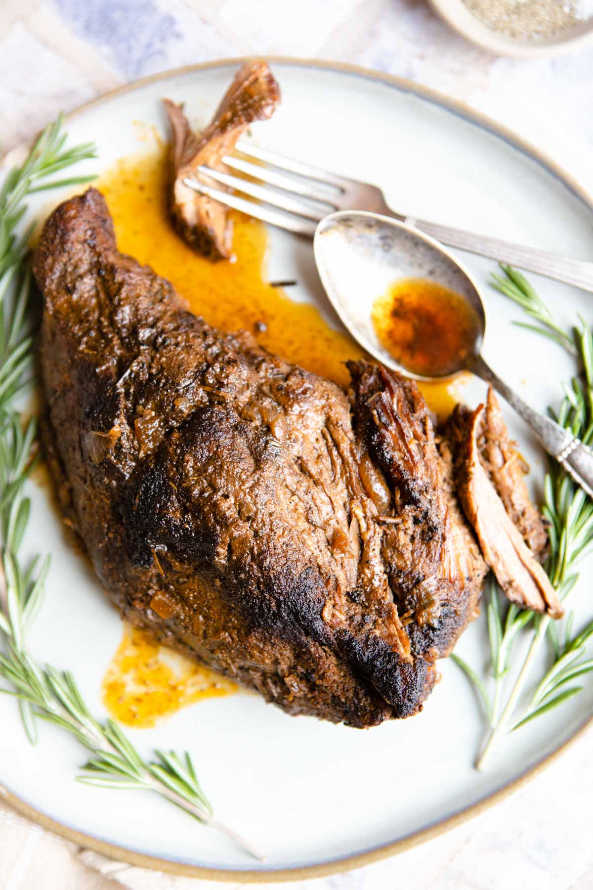 tri tip crock pot set on a plate with cooking liquid