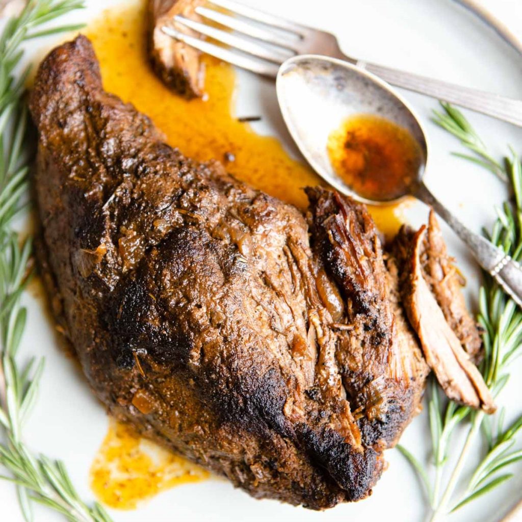 slow cooked tri tip on a platter garnished with rosemary sprigs