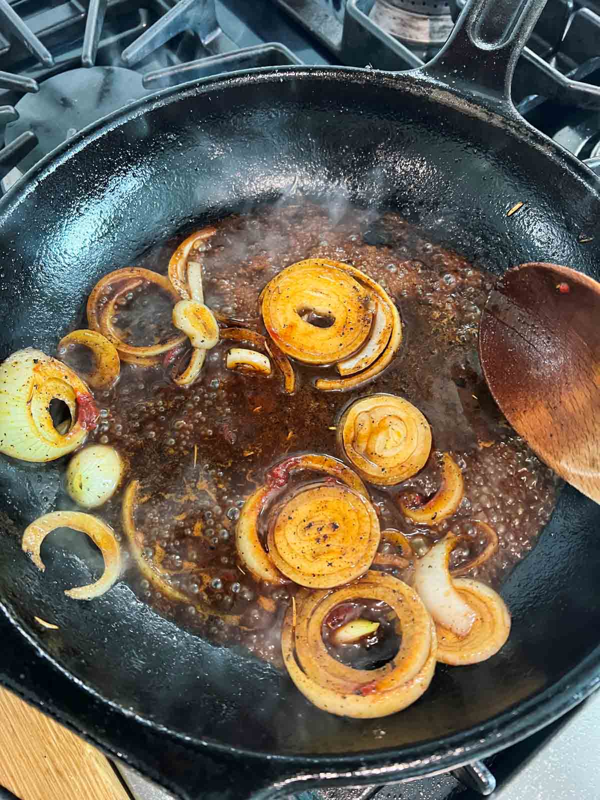 onions and beef broth in a hot cast iron skillet