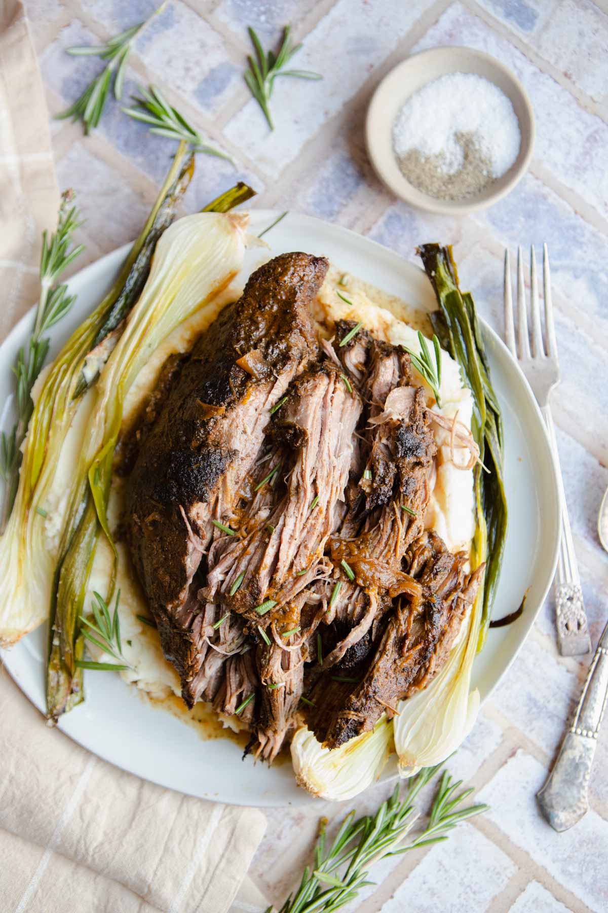 slow cooked tri tip crock pot recipe set on a platter of mashed potatoes 