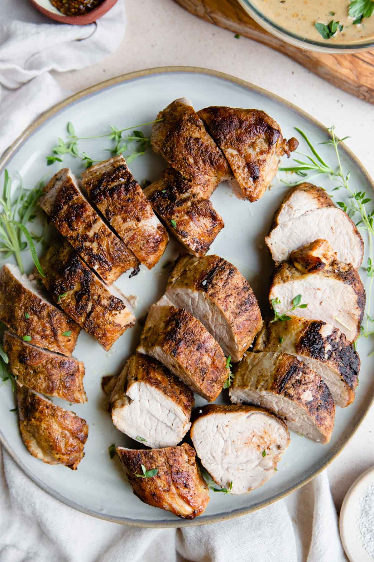 cooked and rested pork tenderloin cut and placed on a plate