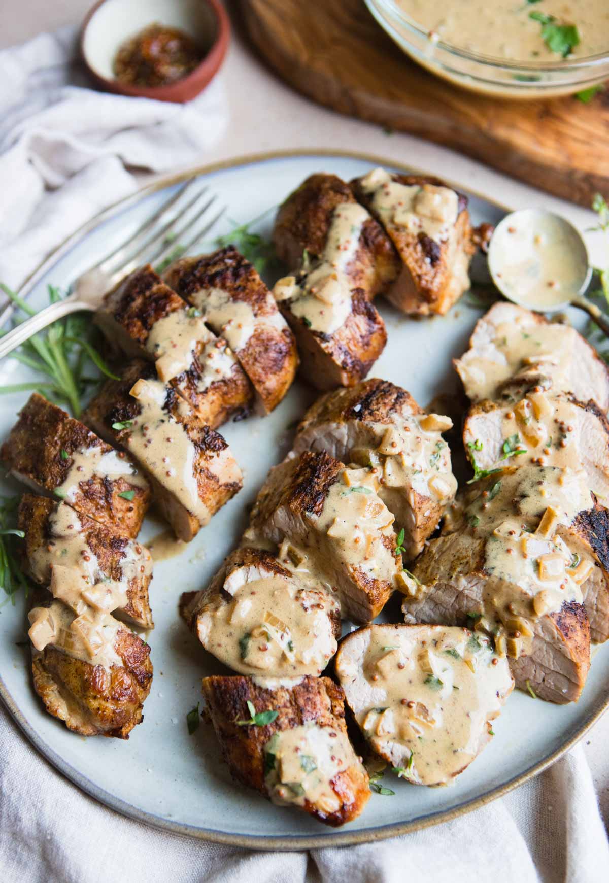 pork tenderloin air fryer recipe cut up and plated with a creamy sauce all over 