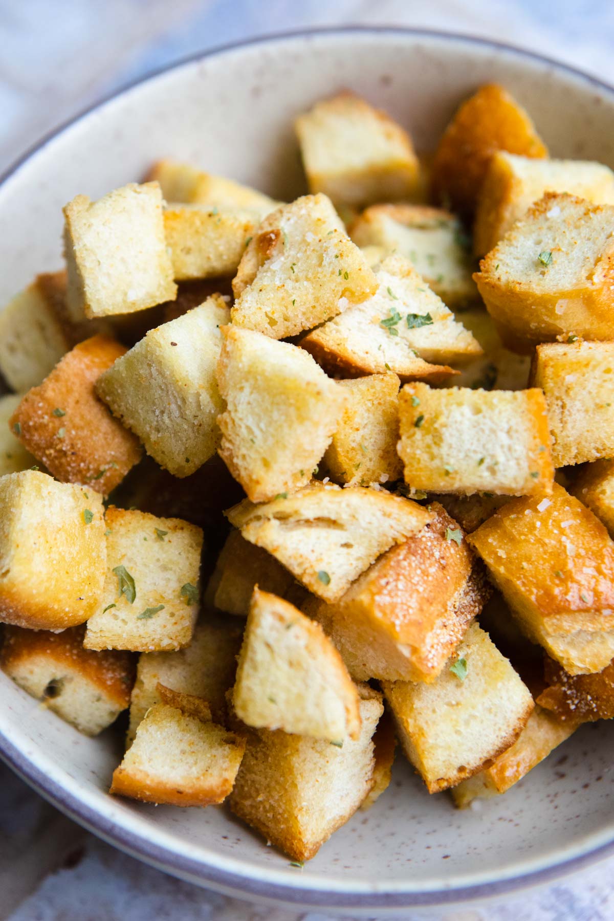 air fried cubes of bread sprinkled with salt in a bowl