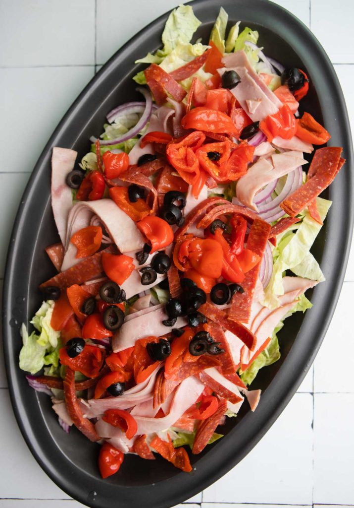peppers, tomatoes and black olives on a cold cut salad