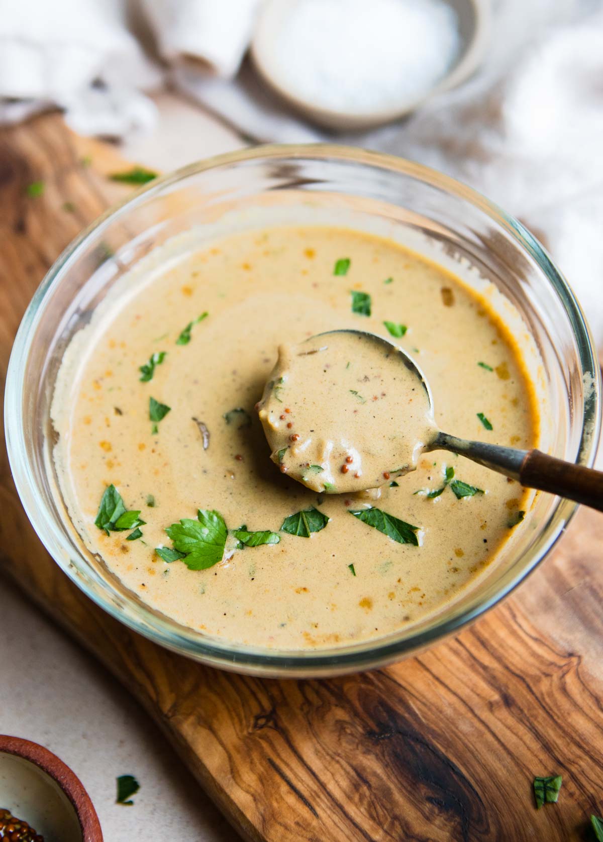 creamy dijon mustard sauce in a glass bowl with wooden spoon