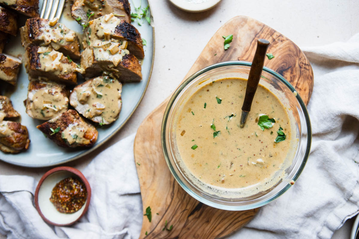 creamy dijon mustard sauce in a glass bowl and also poured onto air fryer pork tenderloin 