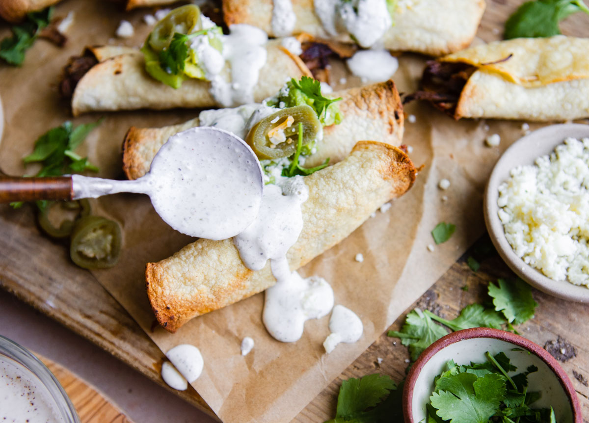 spicy ranch dressing poured over taquitos