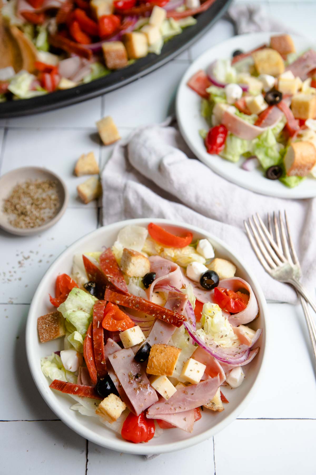 Italian sub salad with homemade croutons served on 2 white plates 