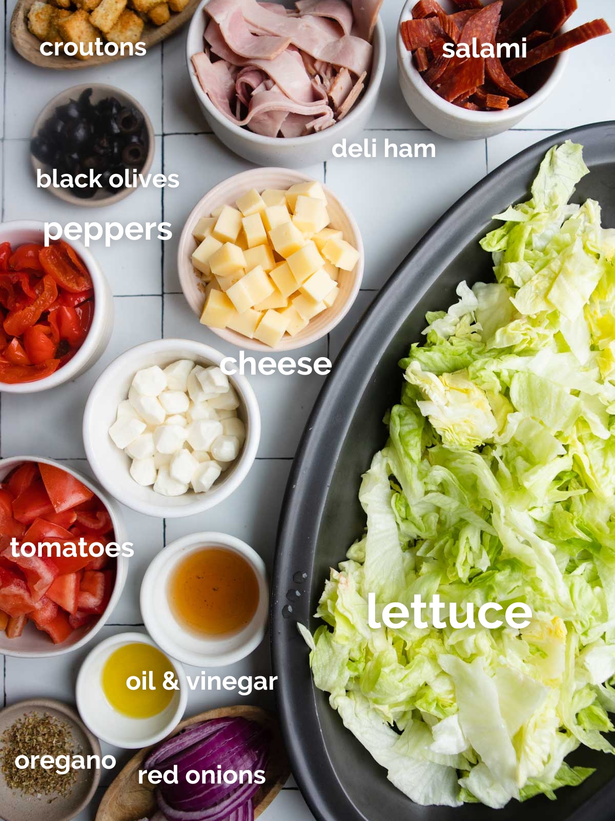 ingredients for Italian sub salad in small white bowls