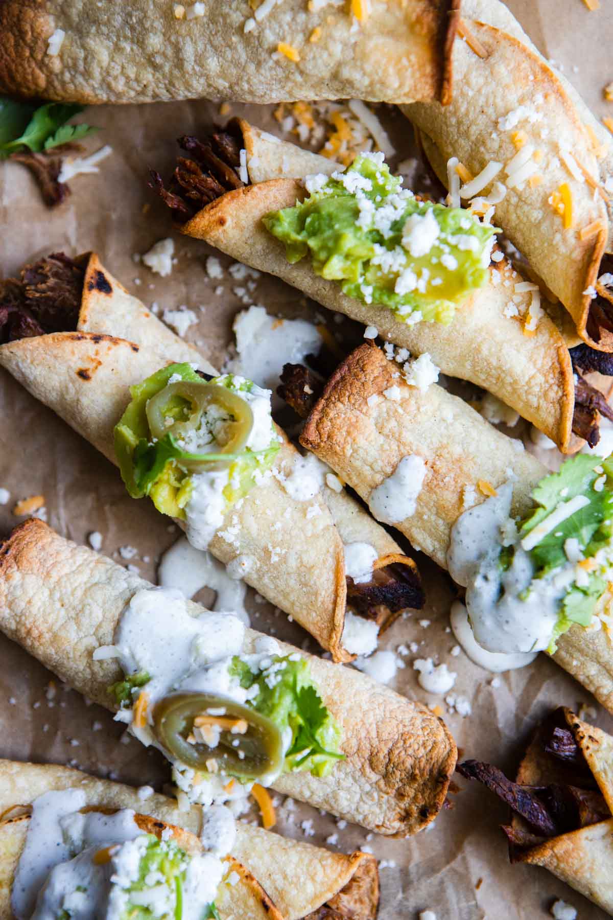 air fryer taquitos made with shredded beef filling and topped with guacamole 