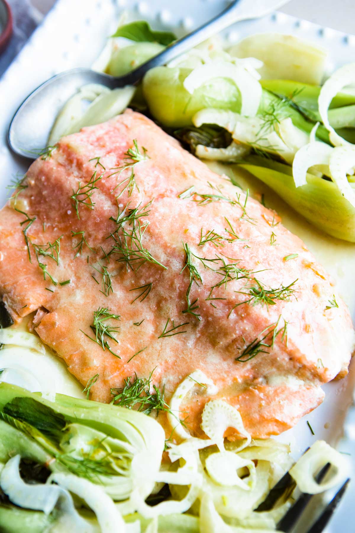 miso butter salmon garnished with cooked fennel and baby bok choy on a white platter