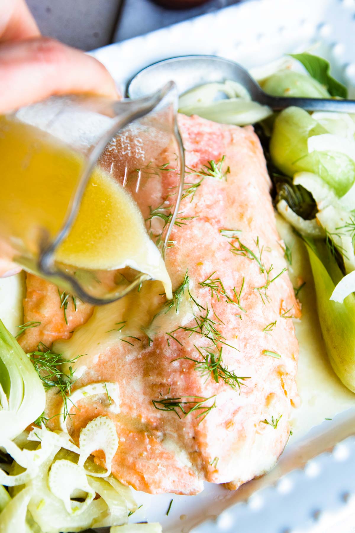 miso butter being poured over salmon filet