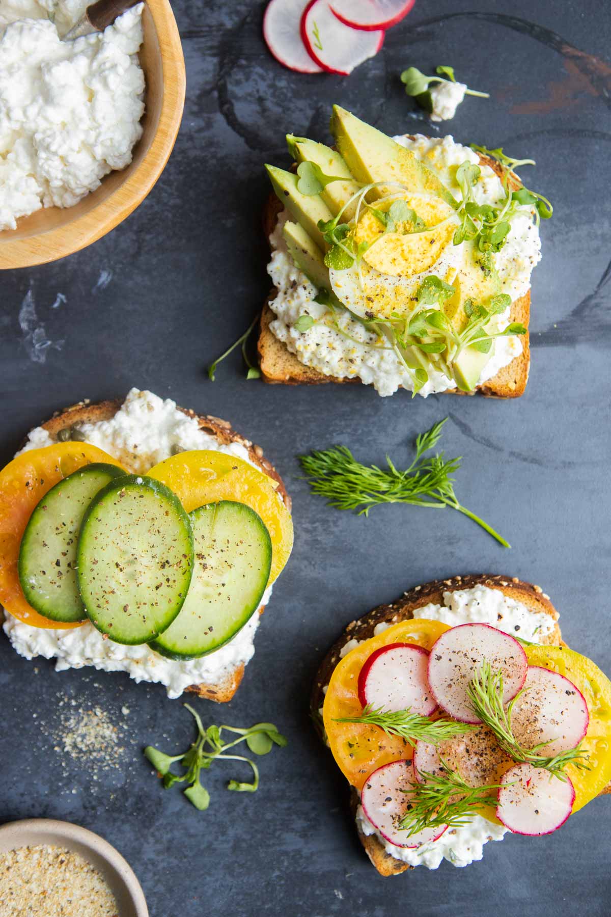 toast with cottage cheese spread on it and various vegetable toppings 