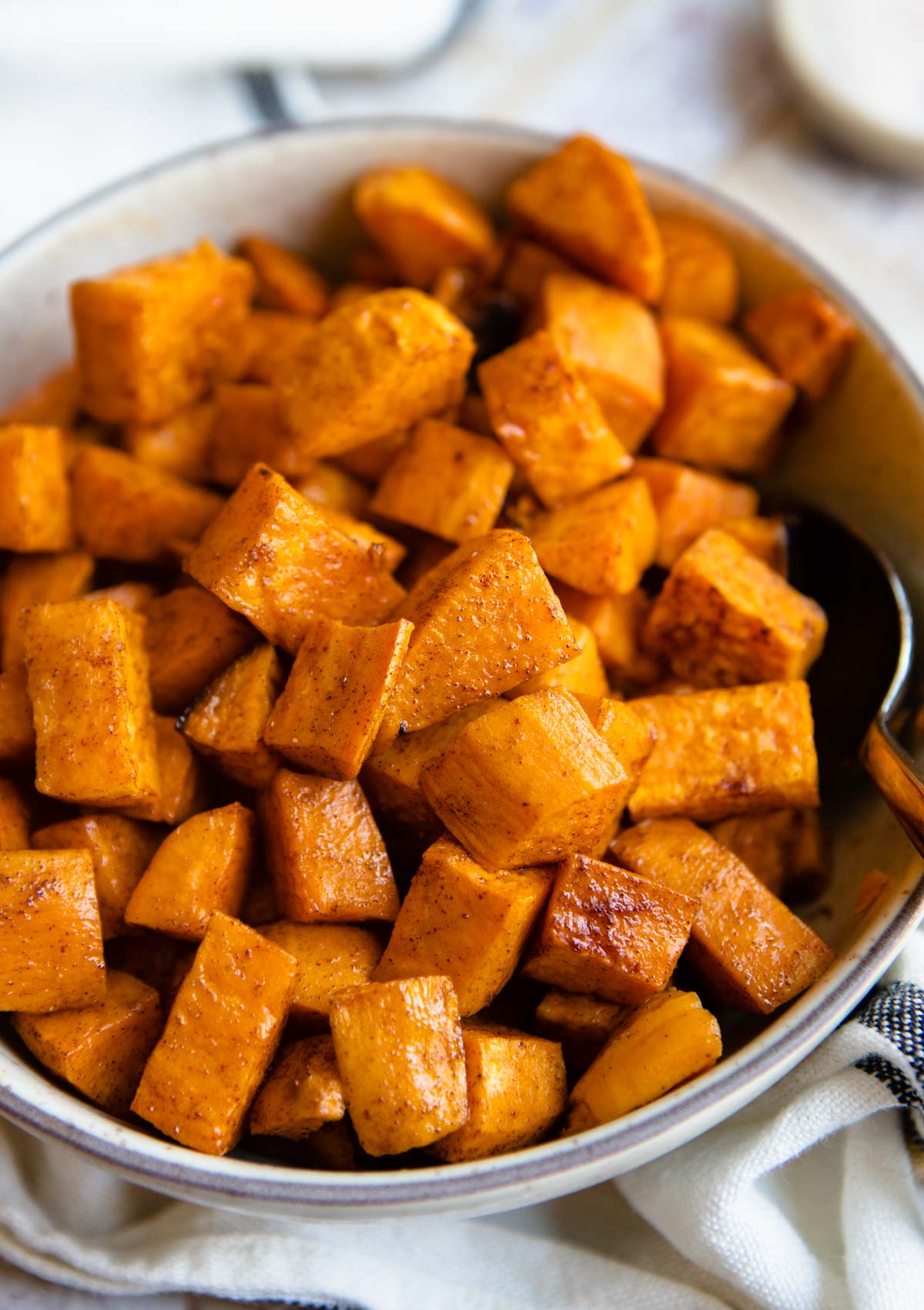 roasted spicy sweet potatoes in a beige bowl 