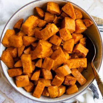 bowl of roasted sweet potatoes sprinkled with cinnamon