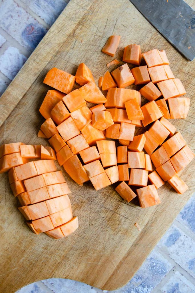 peeled and cubed sweet potatoes on a cutting board