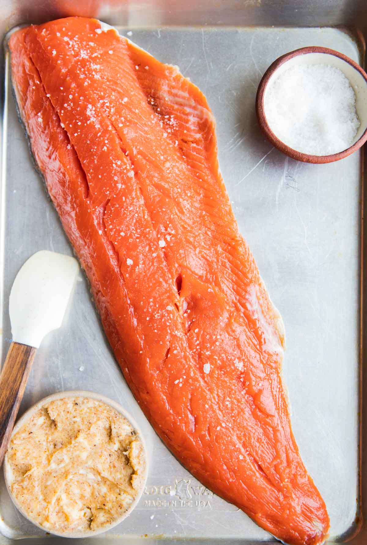 Cajun honey butter in a small bowl set next to a large salmon filet