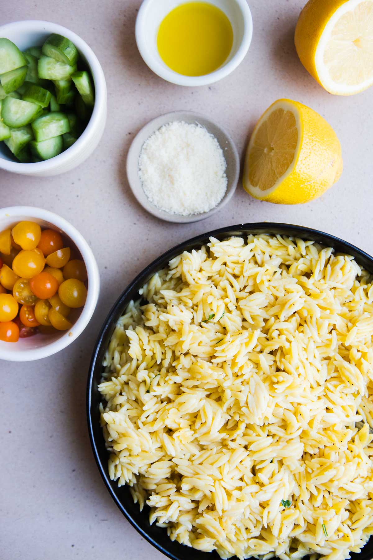 Ingredients shown are used to prepare a zesty lemon orzo salad to share as a side dish or salad.