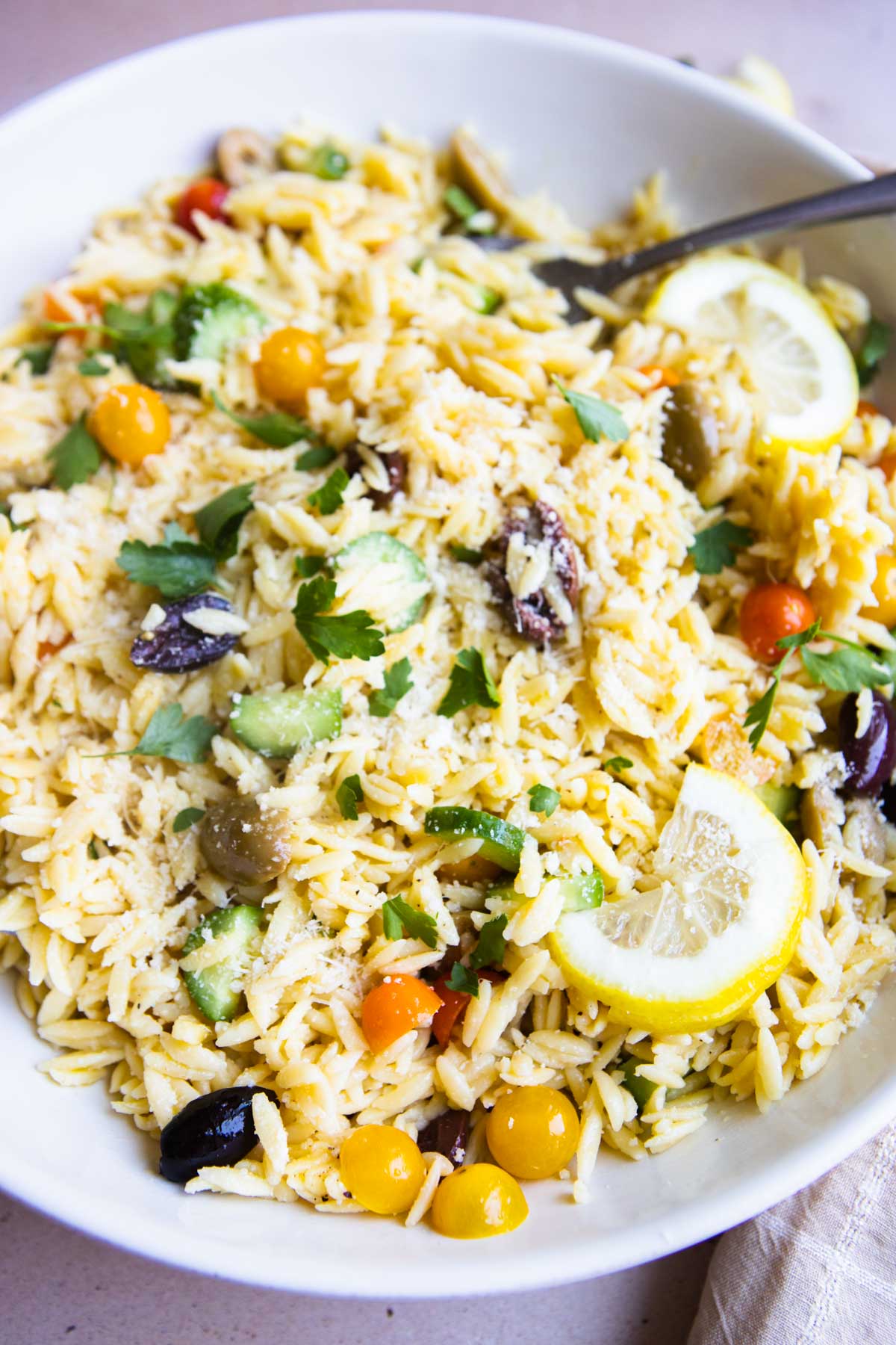 Lemon slices garnish a bright bowl of Lemon orzo salad.