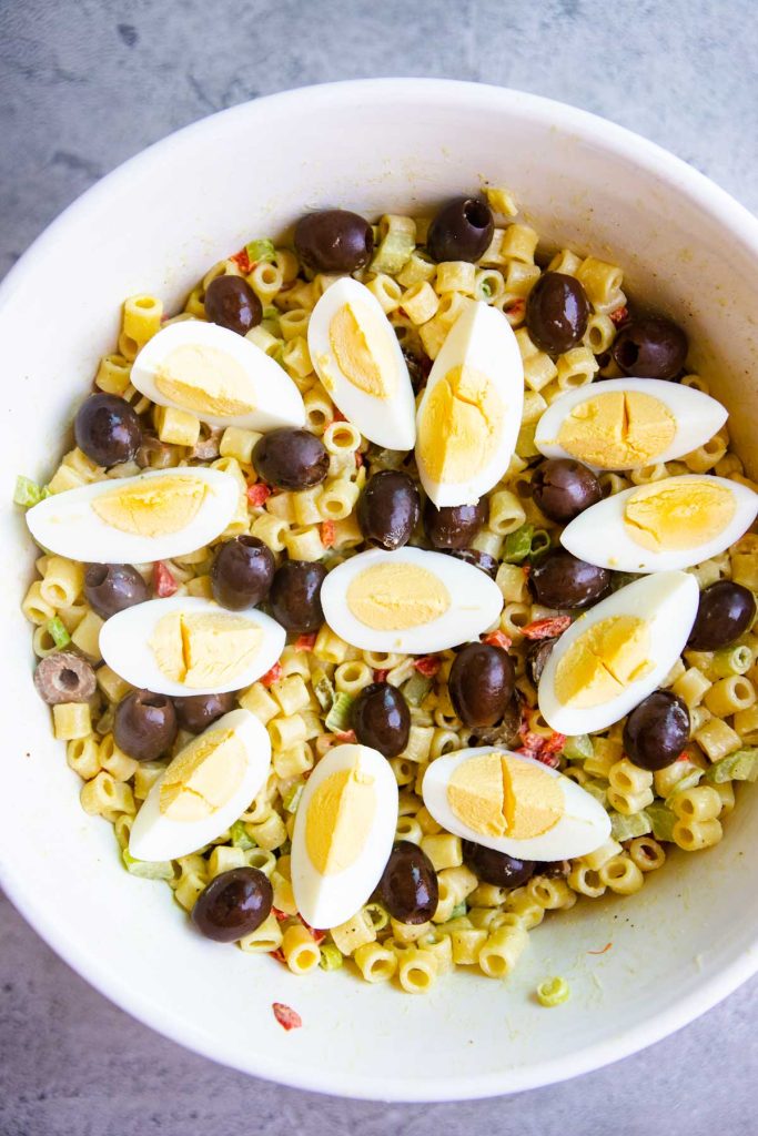 Hardboiled eggs cut into wedges and places over the Southern Macaroni salad with black olives interspersed between.