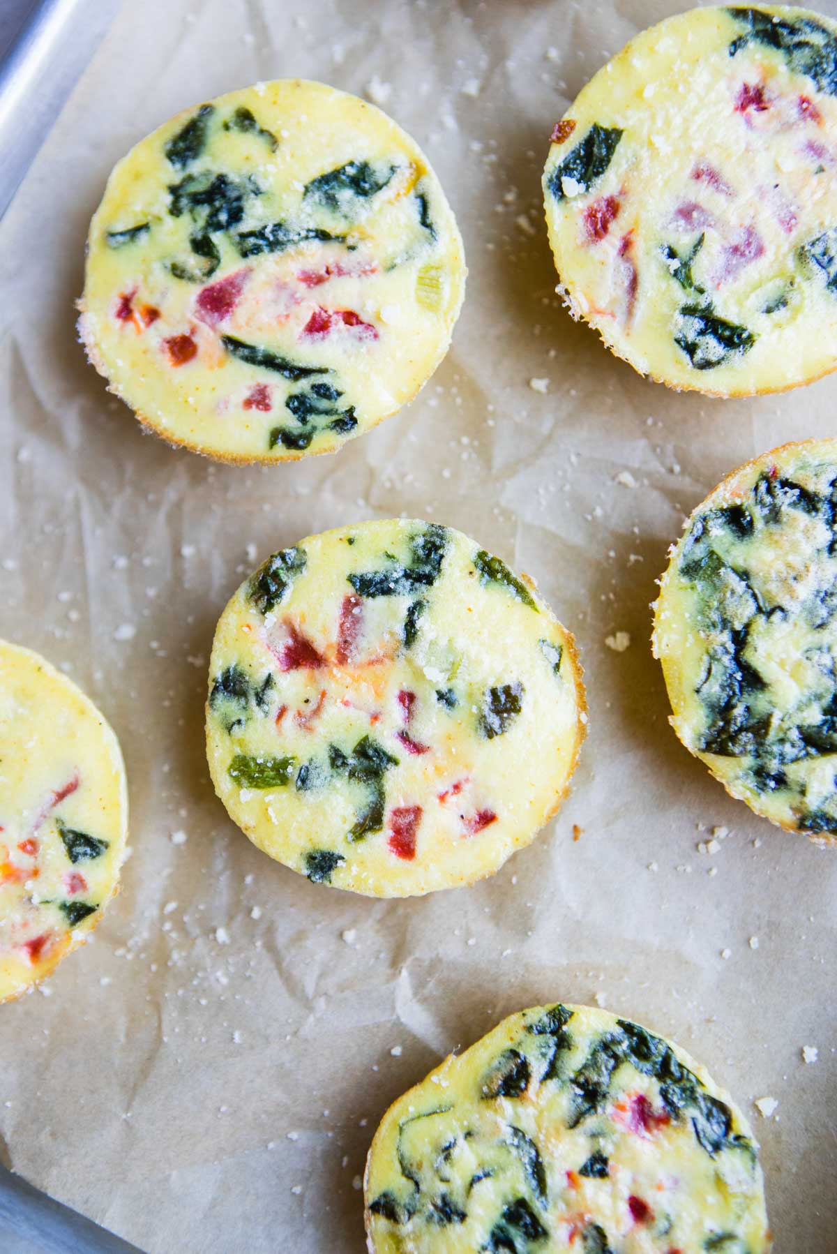 Starbucks egg white bites on parchment paper with parmesan cheese sprinkled on top 