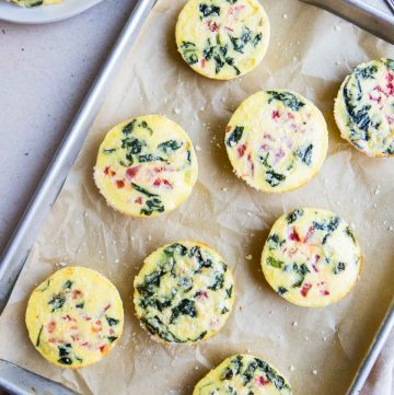 Egg bites on parchment covered baking dish.