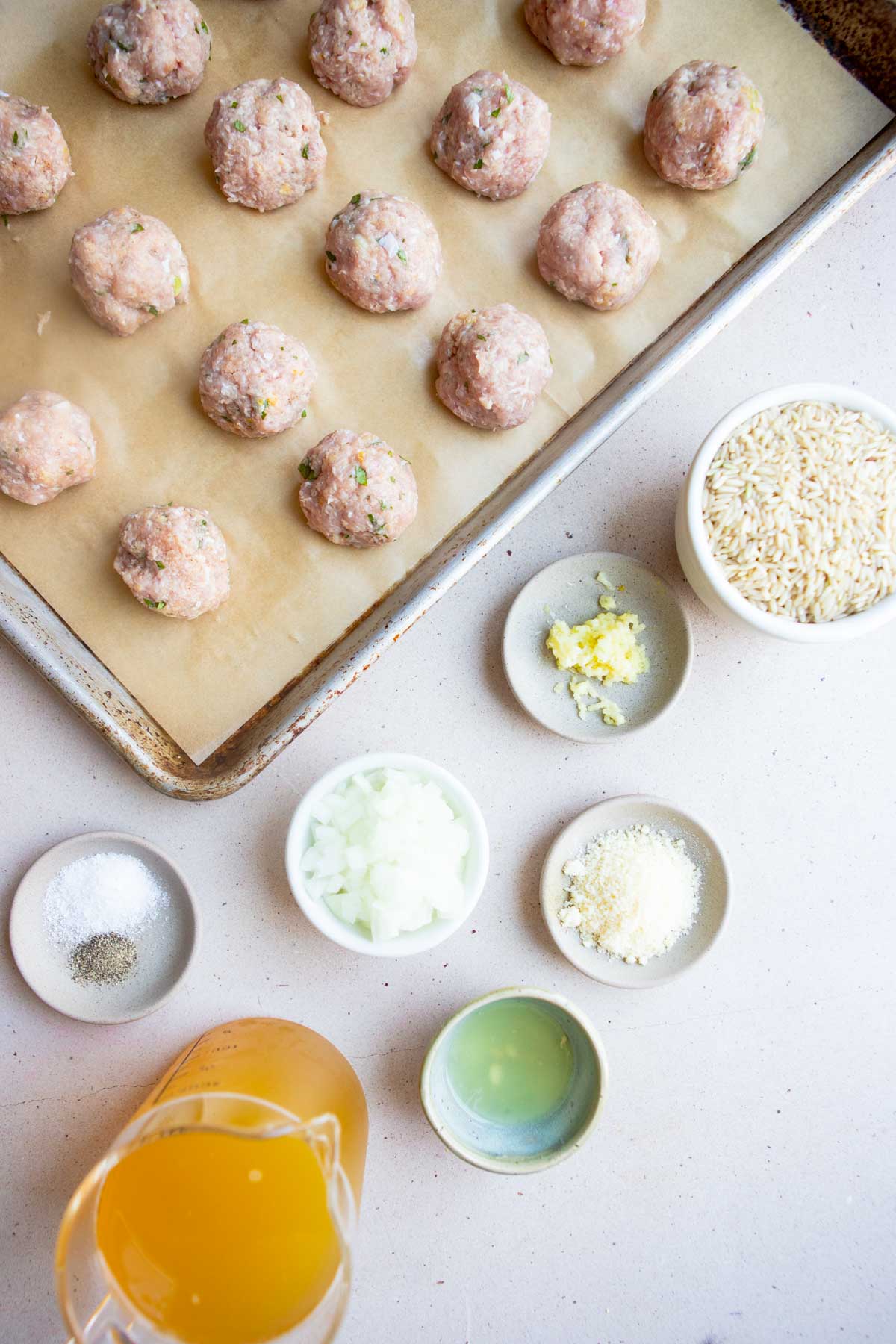 raw turkey meatballs and ingredients to make one pan meatballs and rice all placed in little white bowls 