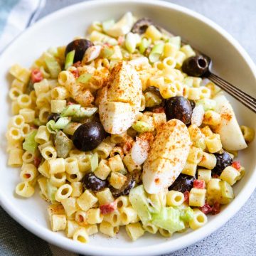 macaroni salad in a white bowl and garnished with hardboiled eggs