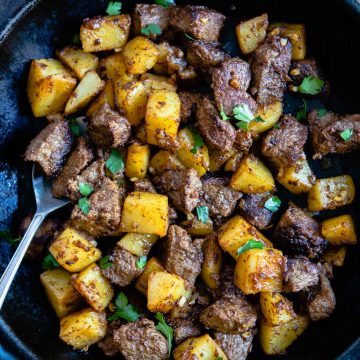 beef sirloin tip steak cooked in a cast iron skillet with bite size potatoes