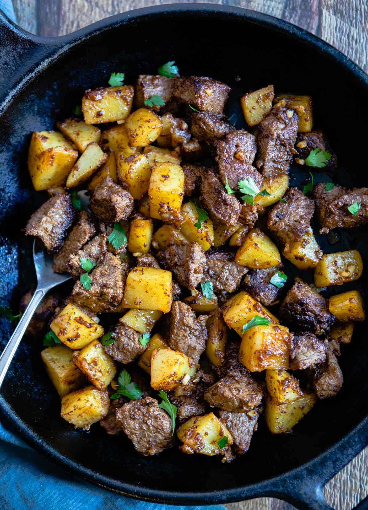 beef sirloin tip steak cooked in a cast iron skillet with bite size potatoes 