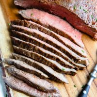 flank steak cooked in the air fryer sliced thinly on the bias, on a cutting board