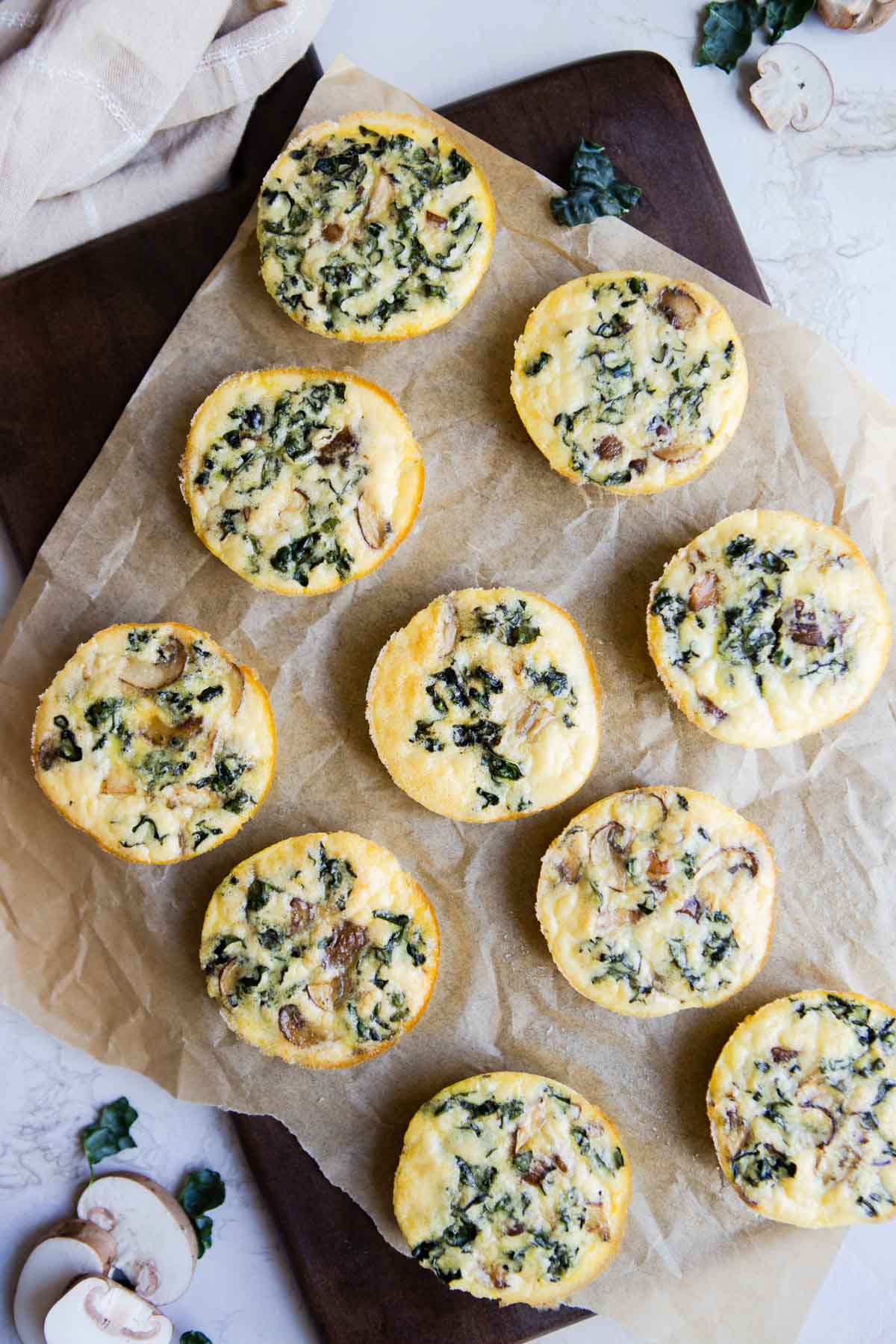 cooked kale and mushroom egg bites on a piece of parchment paper 
