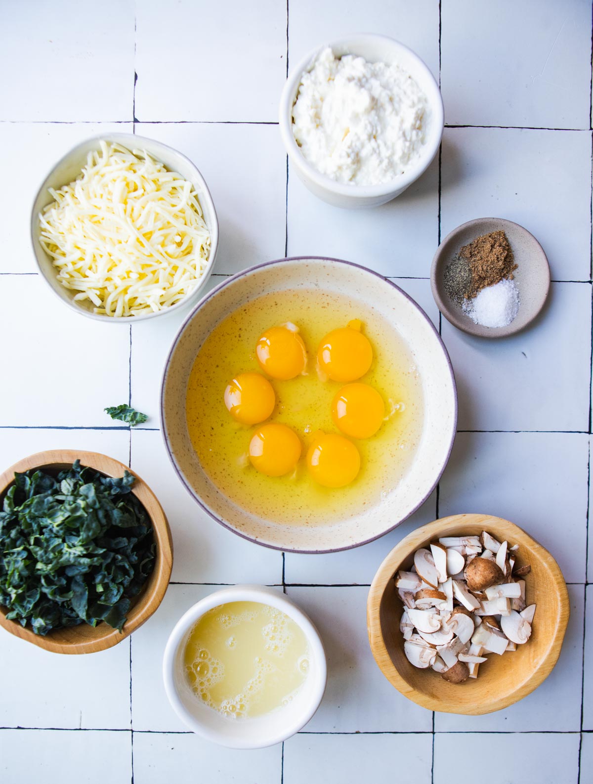 raw ingredients to make kale mushroom egg bites in small bowls