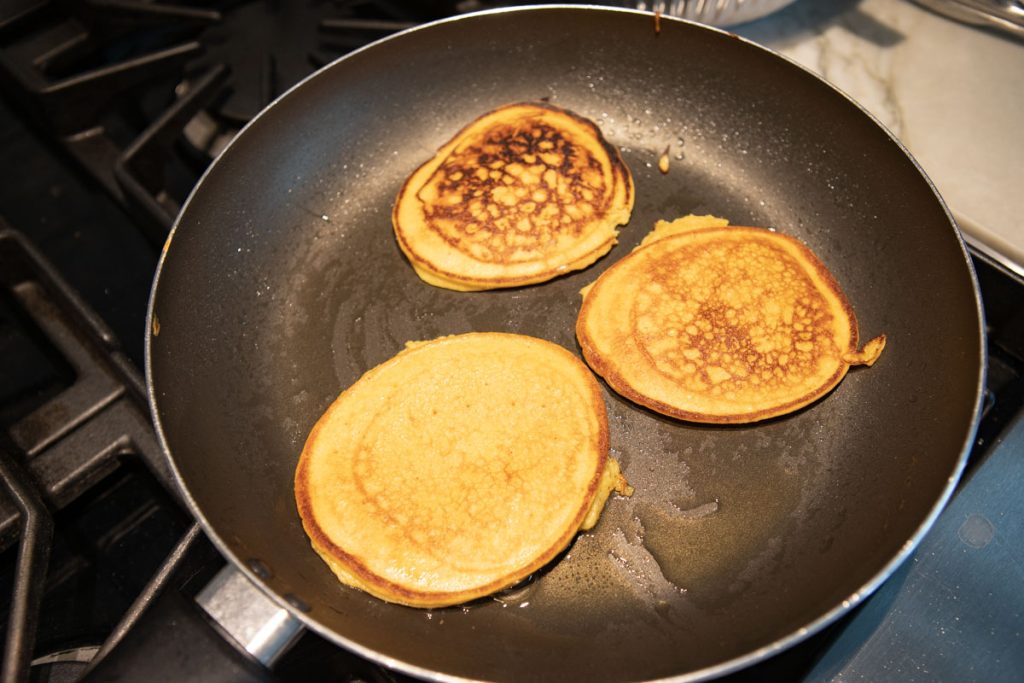 pumpkin protein pancakes cooking in a warmed skillet 
