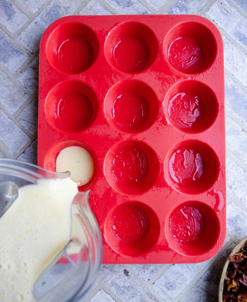 silicone mold being filled with an egg and cheese mixture to make egg bites 