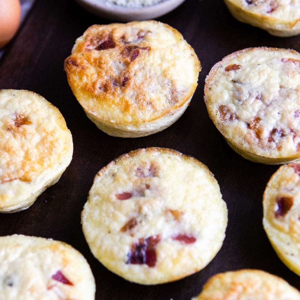 bacon and gruyere egg bites on a wooden platter