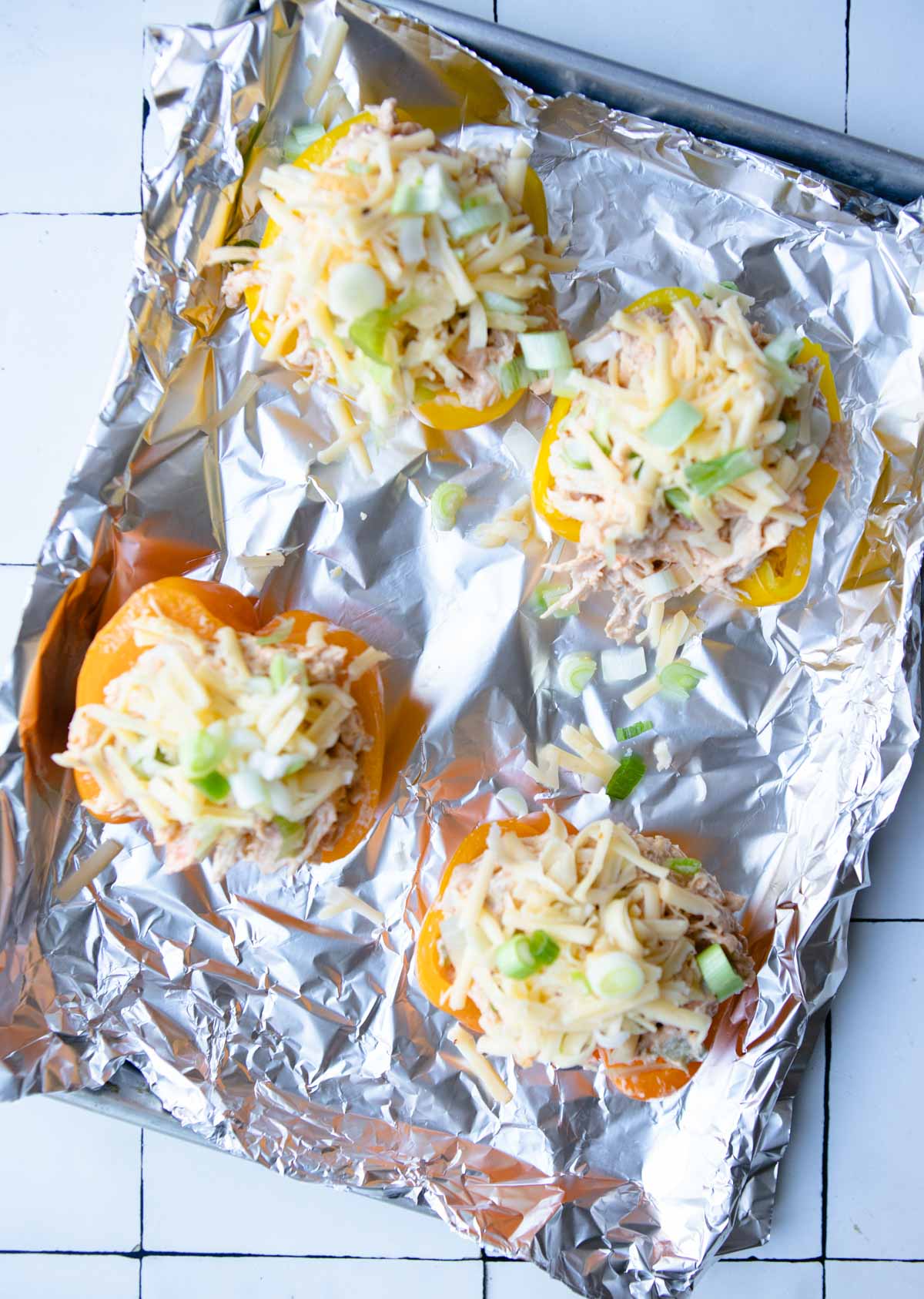 uncooked buffalo chicken stuffed peppers on a sheet pan ready to go in the oven