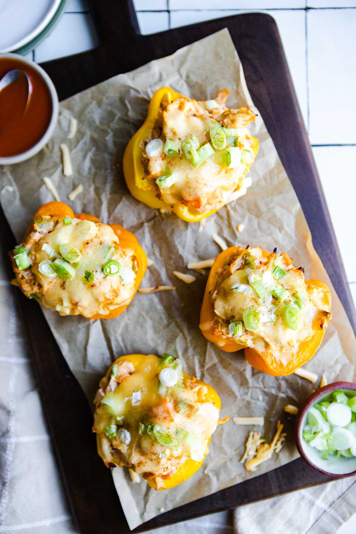 shredded chicken stuffed bell peppers garnished with green onions and melted cheese