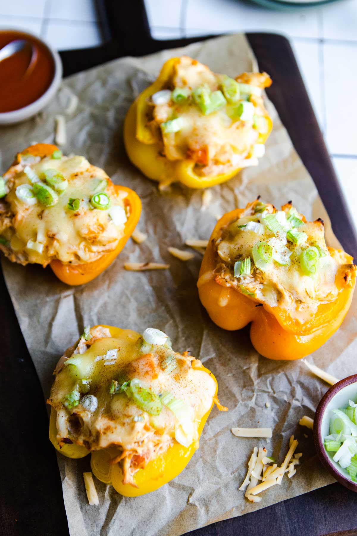 4 buffalo chicken stuffed peppers on a wooden board 