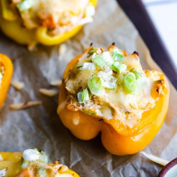 cooked buffalo chicken stuffed peppers garnished with green onions