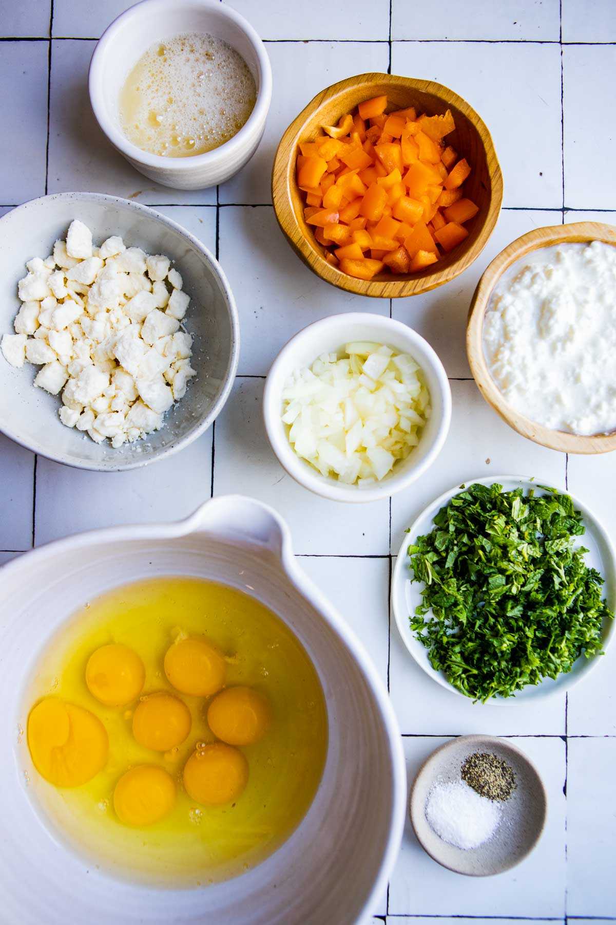 raw ingredients to make cottage cheese egg bake in small white bowls 