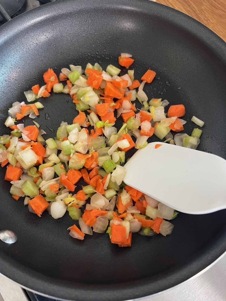 diced onions, carrots and celery in a saute pan 