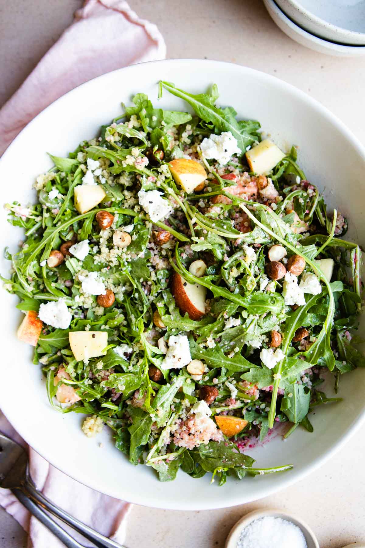 tossed arugula salad in a large white bowl