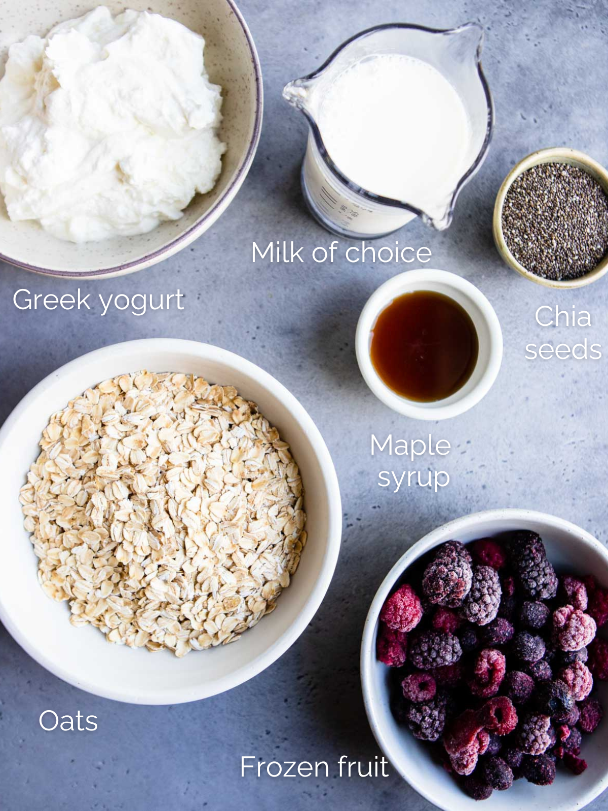 ingredients to make overnight oats with frozen fruit in white bowls