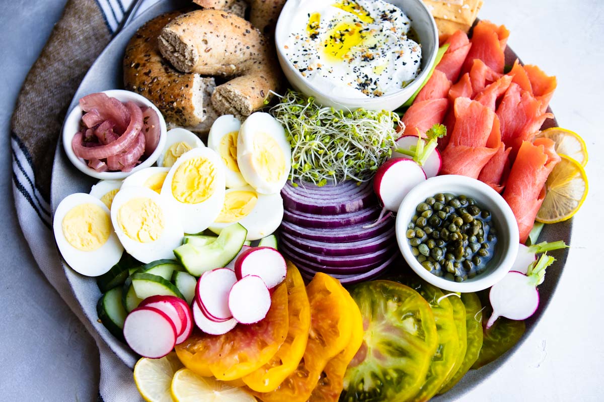 ingredients for a salmon charcuterie board spread out on a round platter