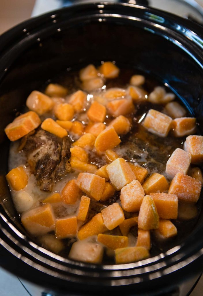 frozen squash added to the slow cooker with pork shoulder 
