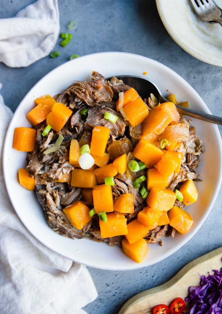 cooked pork and squash in a white bowl 