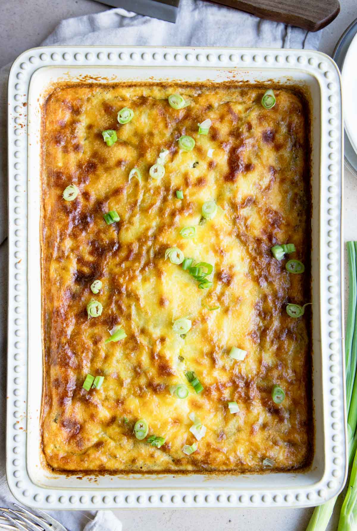 baked eggs and asparagus topped with green onions 