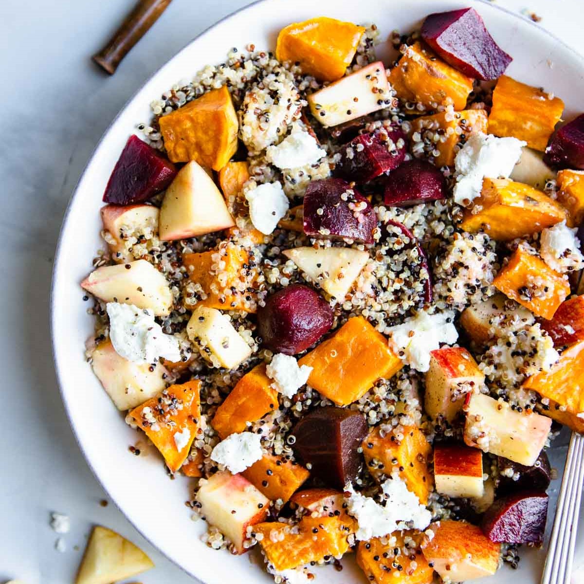 close up of a beet and quinoa salad served in a wide white bowl 